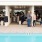a group of people standing around a pool