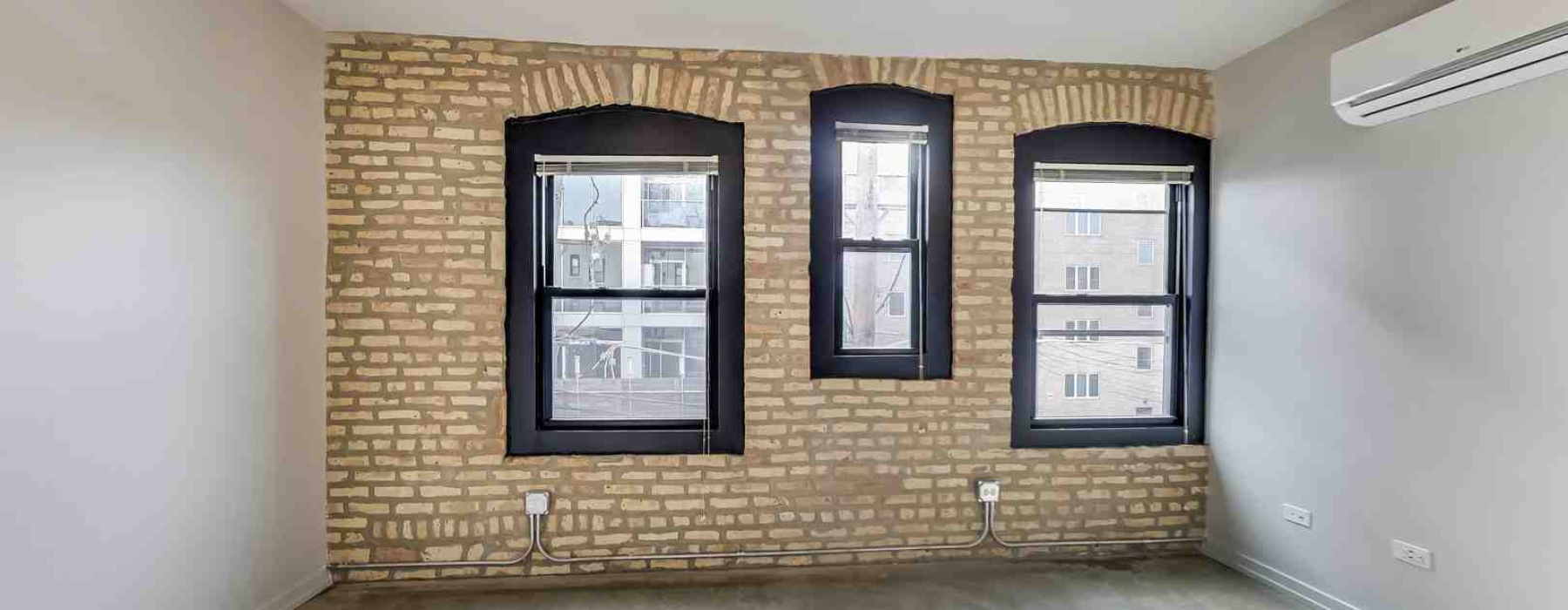 modern apartment living room with air conditioning unit and sunlight streaming through windows - air conditioning unit cost apartment