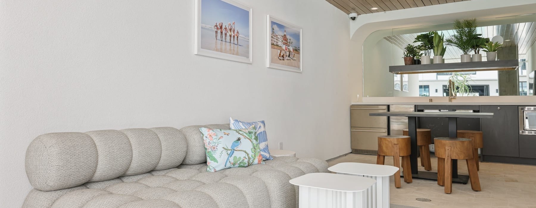 a white couch with a table and chairs in a room with plants